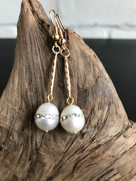 These Swarvorski drop pearl earrings with inlaid crystals are THE perfect finish to any outfit. Available in gold or silver, the 2 inch length will show off the large pearl with inlaid crystals.