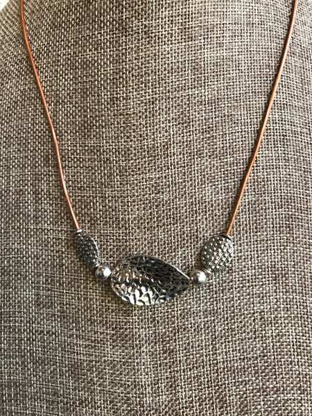 Unique pewter beads and natural leather! Custom designed and crafted by Dixie Klein. 19 inches long.