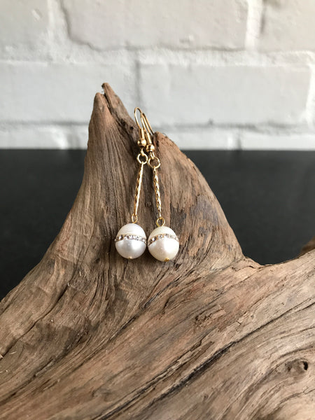 These Swarvorski drop pearl earrings with inlaid crystals are THE perfect finish to any outfit. Available in gold or silver, the 2 inch length will show off the large pearl with inlaid crystals.
