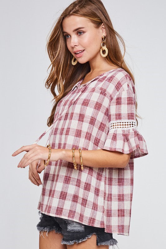 This precious top from LLove features a checkered print, ruffle and lace sleeve detail, and a relaxed fit. Comes in Small - Large. 