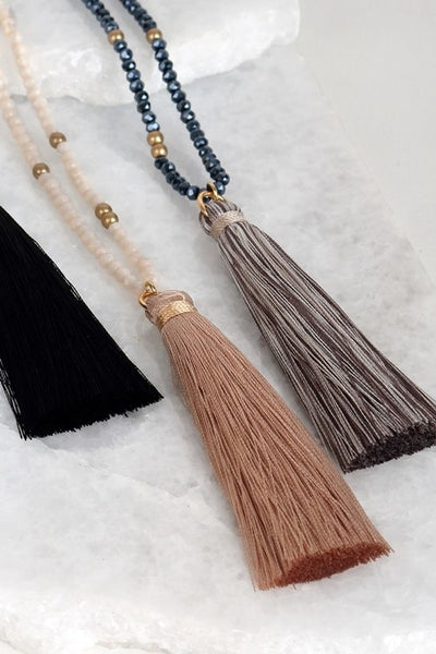 This lovely mixed glass necklace is brought to you by Urbanista. It is 32" long with a 3" extender and features a fine thread tassel pendant.