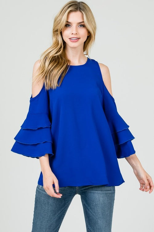Keep it cool and fun in this royal blue cold shoulder cold shoulder top from Ces Femme.  It features a tiered trumpet sleeve and a round neckline. 