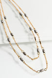 This beautiful layered chain and glass bead short necklace is by Urbanista. It features two delicate layers. Comes in Grey and Brown. 