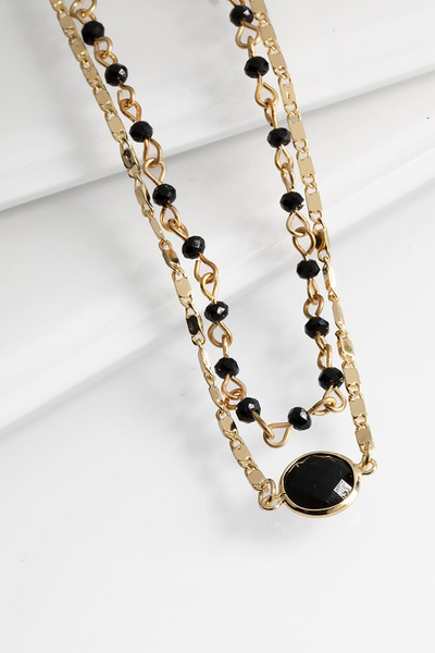 This delicate double layered bead necklace features a crystal charm and ﻿an interesting gold chain. It is 16" long with a 3" extender. Comes in Blush, Crystal, and Black.