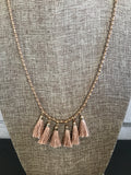 Casual and trendy 6 tassel and beaded 32 inch necklace. The faceted beads have a tiny touch of peach color and are separated by gold seed beads. It has a 3 inch extender. 