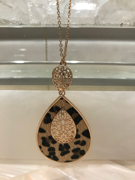 This long 33 inch necklace has a beautiful 3 1/4” inch genuine leather and faux fur animal print teardrop pendant with a filigree accent.  It comes in grey embossed or brown leopard and looks great with our Ces Femme tops! 