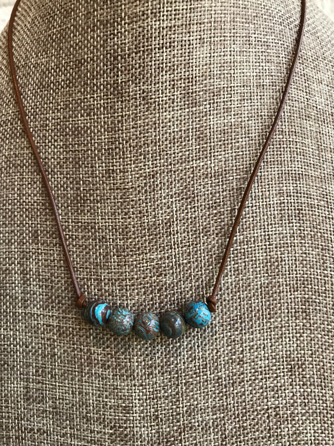 Beautiful blues and browns are highlighted in this natural 5 stone jasper necklace with brown leather created by Dixie Klein. Length - 17 inches