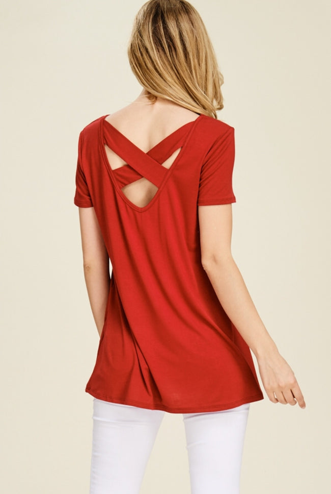 This cute little top has a cut out back with criss cross straps to add just a little extra. Perfect with white leggings, shorts or even a skirt! Easy care rayon and spandex fabric. Available in red or atlantis green. 