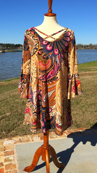 Add this beautiful tunic top to your collection that features a comfortable, flowy, fabric, criss cross neckline at the front and back, finished split bell sleeves, and a gorgeous print that's perfect for pairing with solid leggings or skirts. 92% polyester 8% spandex.