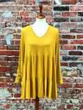 This mustard ruffled tunic has a romantic lace insert on the sleeve. Wear it with shorts, a skirt, or pants to pull off the perfect fall look. Fits true to size: Small 2/4, Medium 6/8, Large 10/12